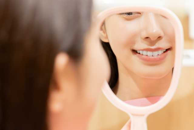 手鏡で歯を確認する女性